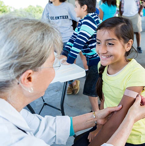 A nurse providing a vaccination to a young girl